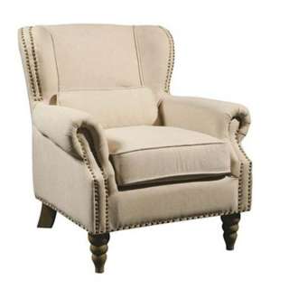 Linen covered wing chair on hand carved oak frame is edged with hand 